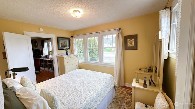 bedroom with hardwood / wood-style flooring and a textured ceiling