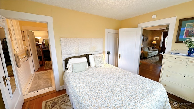 bedroom with dark hardwood / wood-style floors and a textured ceiling