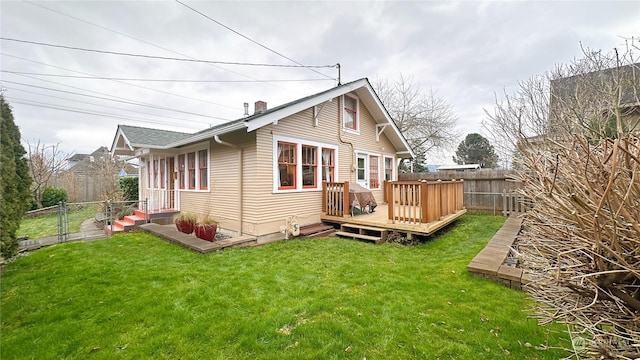 back of house featuring a wooden deck and a lawn