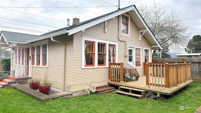 back of house with a wooden deck and a lawn