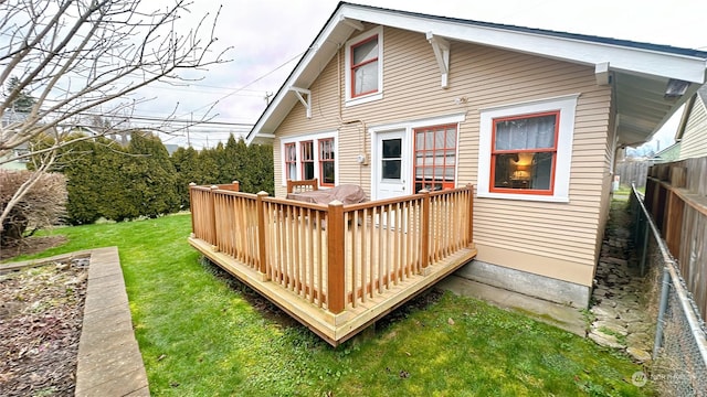 rear view of house with a wooden deck and a lawn