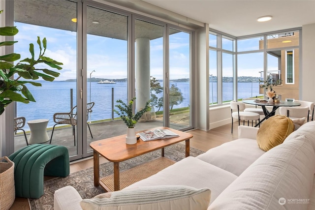 sunroom featuring a water view