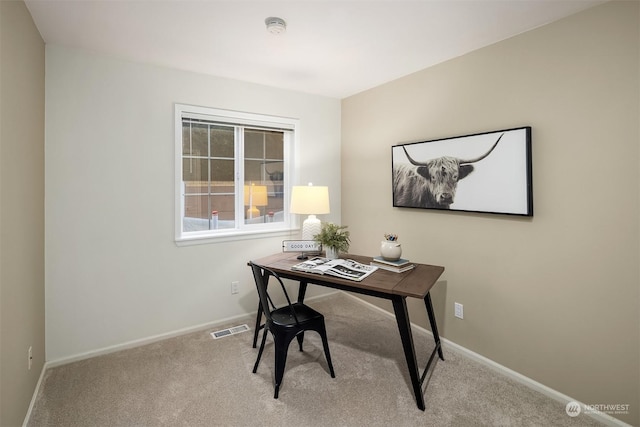 home office featuring light colored carpet, visible vents, and baseboards