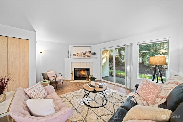 living room with hardwood / wood-style flooring and a tile fireplace