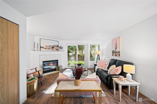 living room featuring hardwood / wood-style flooring and a tile fireplace