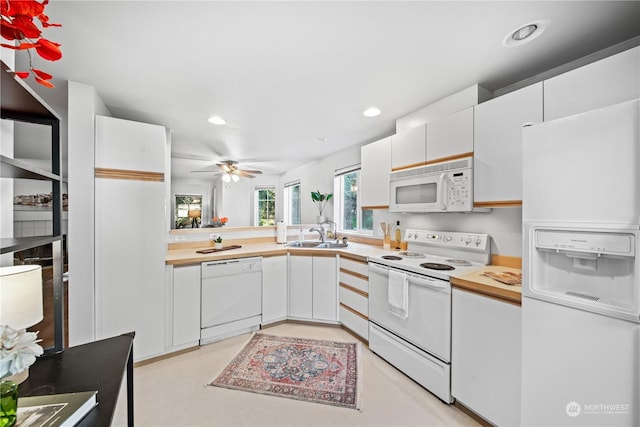 kitchen featuring white appliances, sink, and white cabinets