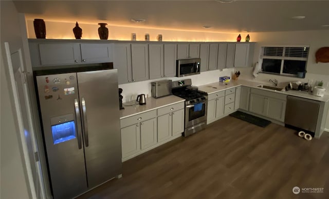 kitchen featuring dark wood-type flooring, appliances with stainless steel finishes, and sink