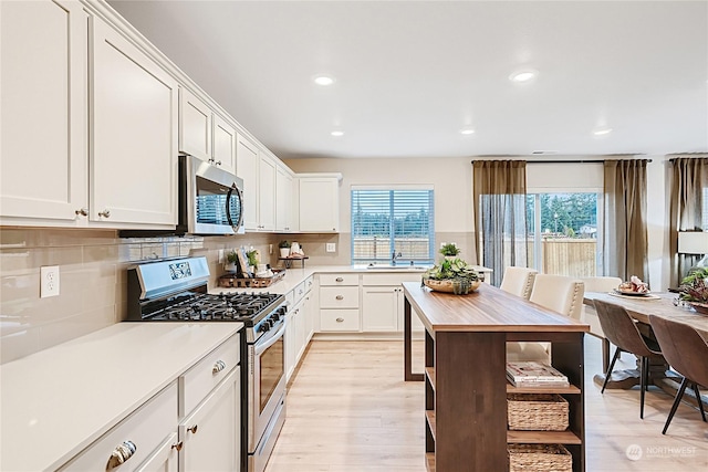 kitchen featuring white cabinetry, appliances with stainless steel finishes, and light hardwood / wood-style floors