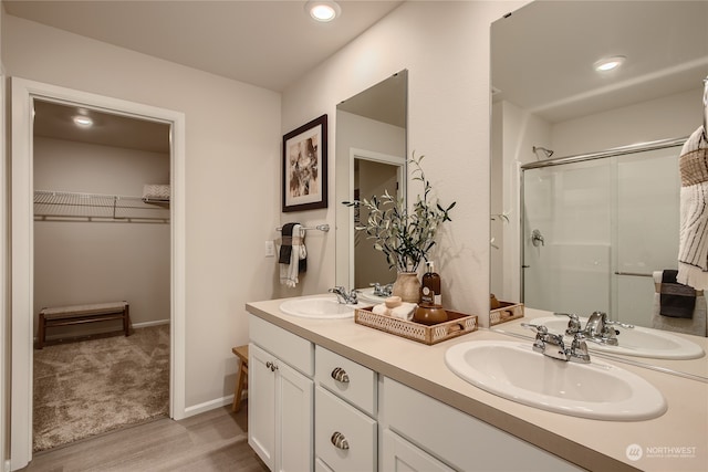 bathroom featuring a shower with door, vanity, and hardwood / wood-style floors