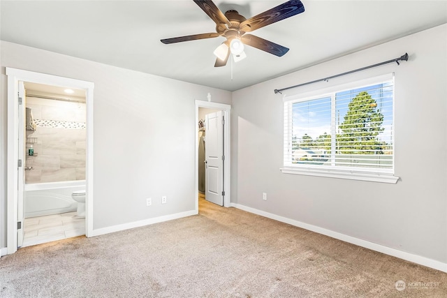 unfurnished bedroom with ceiling fan, light colored carpet, and ensuite bath