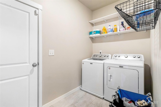 clothes washing area featuring washing machine and dryer and light tile patterned floors