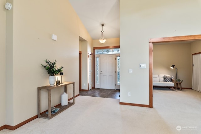 foyer featuring carpet flooring and high vaulted ceiling