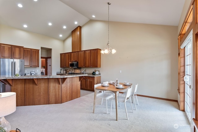 kitchen with a kitchen island, a breakfast bar, a chandelier, hanging light fixtures, and stainless steel appliances