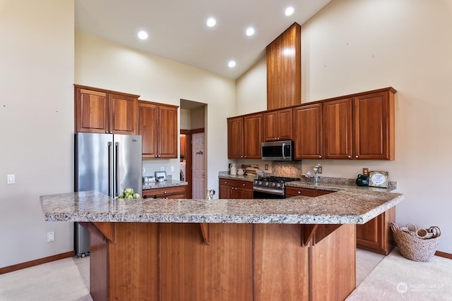 kitchen featuring stainless steel appliances, high vaulted ceiling, a center island, and a kitchen bar