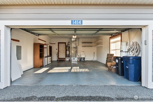 garage featuring electric panel, sink, and gas water heater