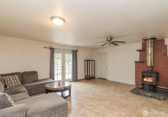 living area with a wood stove, a ceiling fan, and french doors