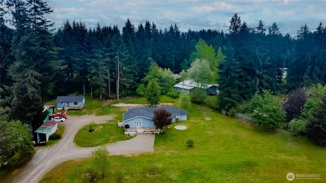 aerial view of property and surrounding area featuring a heavily wooded area