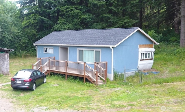14241 State Route 507 SE, Yelm, WA 98597 - view of front of house with a shingled roof, a wooden deck, and a wooded view