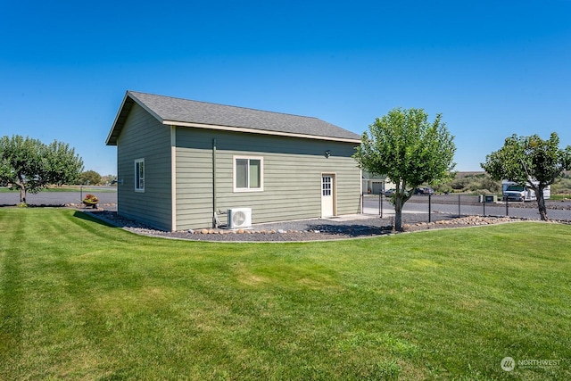 back of house with ac unit and a lawn