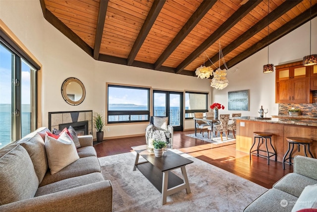 living room featuring beam ceiling, wood ceiling, wood-type flooring, and a water view