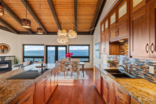 kitchen featuring sink, wood ceiling, a water view, light stone counters, and decorative backsplash