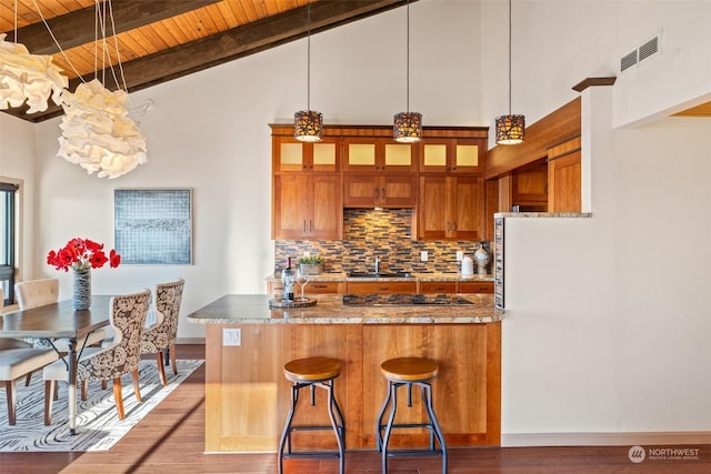 kitchen featuring hardwood / wood-style floors, tasteful backsplash, sink, a breakfast bar area, and wooden ceiling