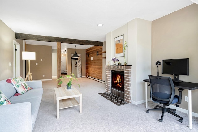 carpeted living room with beamed ceiling, a brick fireplace, baseboard heating, and wood walls