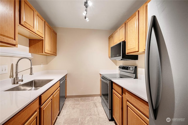 kitchen with rail lighting, appliances with stainless steel finishes, and sink