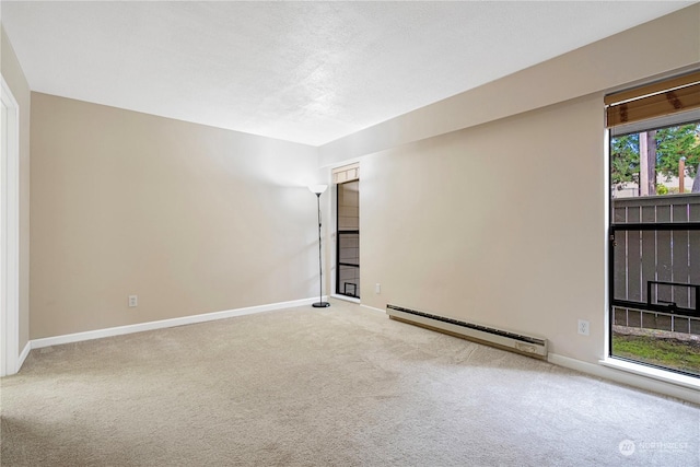 empty room featuring light colored carpet and baseboard heating