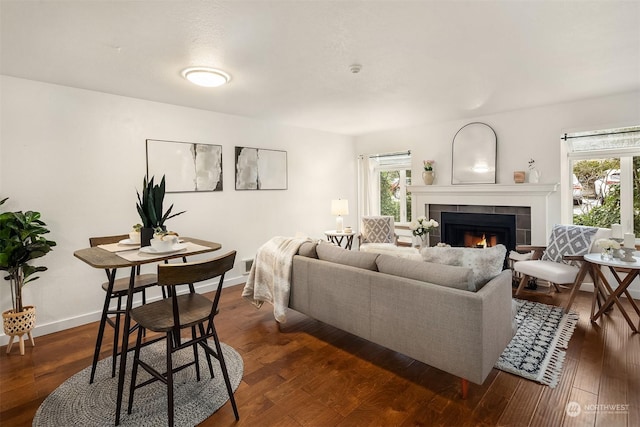 living room with plenty of natural light, dark hardwood / wood-style flooring, and a tiled fireplace