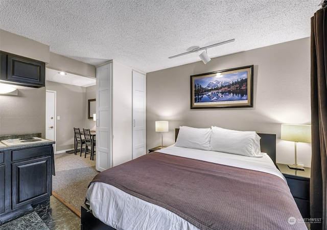 bedroom with rail lighting, ceiling fan, and a textured ceiling