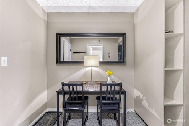 carpeted home office featuring a textured ceiling