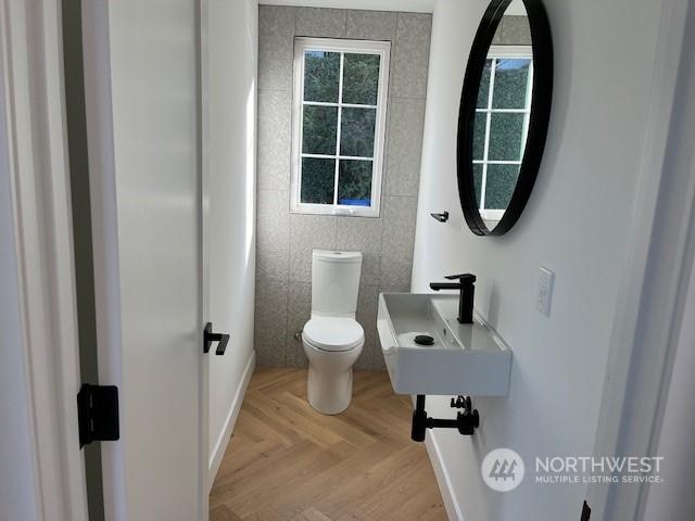 bathroom featuring parquet floors, toilet, and sink