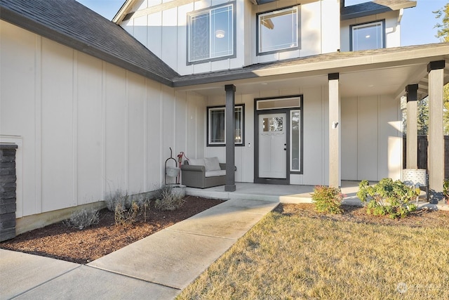 doorway to property with a yard, elevator, and covered porch