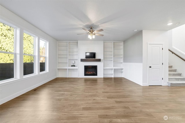 unfurnished living room with light hardwood / wood-style flooring, a fireplace, and ceiling fan