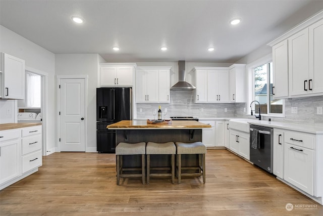 kitchen featuring white cabinetry, black fridge with ice dispenser, and wall chimney exhaust hood