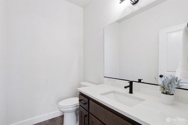 bathroom featuring vanity, hardwood / wood-style floors, and toilet