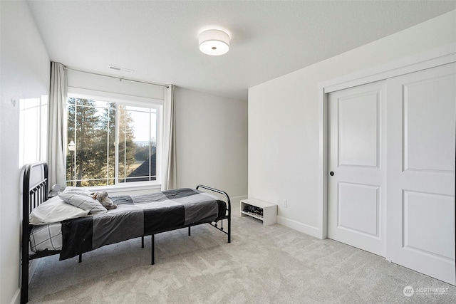 bedroom with light colored carpet and a closet