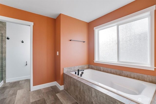 bathroom with hardwood / wood-style flooring and plus walk in shower