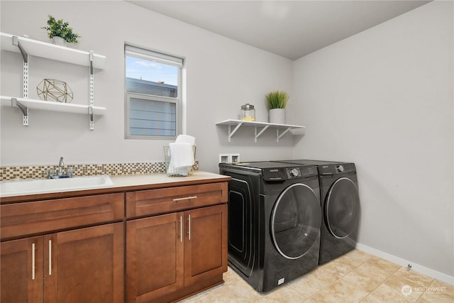 laundry area featuring sink, washing machine and dryer, and cabinets