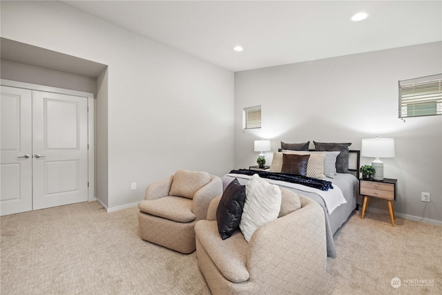 bedroom with light carpet and a closet