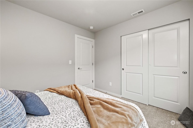 bedroom with light carpet and a closet