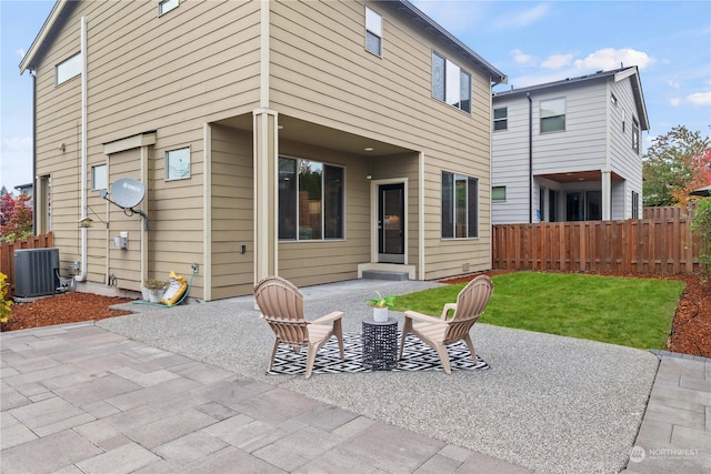 rear view of property featuring a yard, central air condition unit, and a patio area