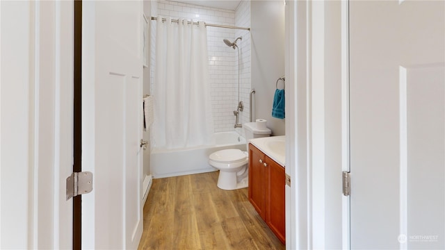 full bathroom featuring hardwood / wood-style flooring, shower / bathtub combination with curtain, vanity, and toilet