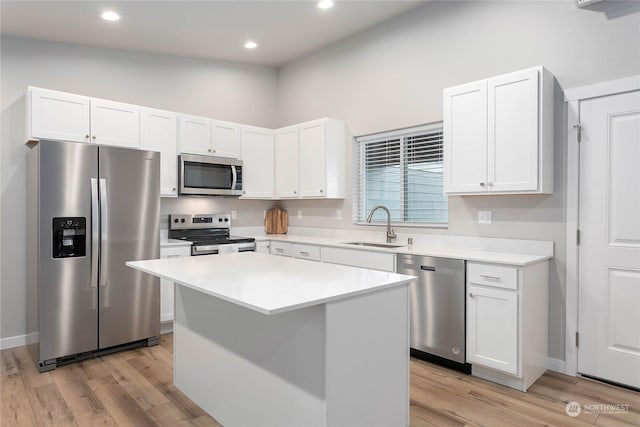 kitchen featuring white cabinetry, appliances with stainless steel finishes, a center island, and sink