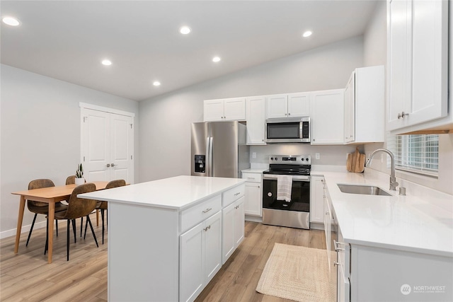 kitchen with white cabinetry, sink, a center island, and appliances with stainless steel finishes