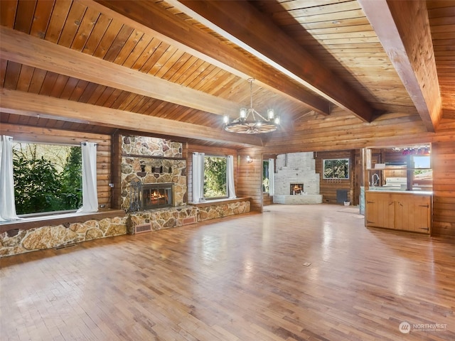 unfurnished living room with light hardwood / wood-style flooring, a fireplace, and a chandelier