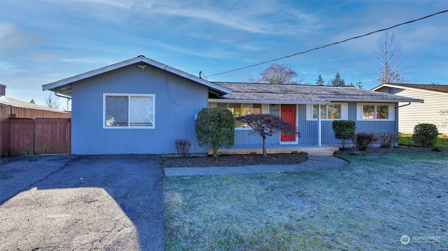 ranch-style house with a front yard and covered porch