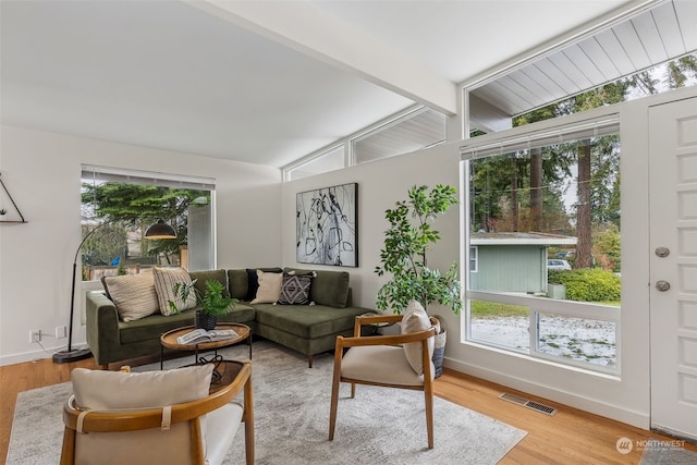 living room featuring hardwood / wood-style flooring and vaulted ceiling with beams