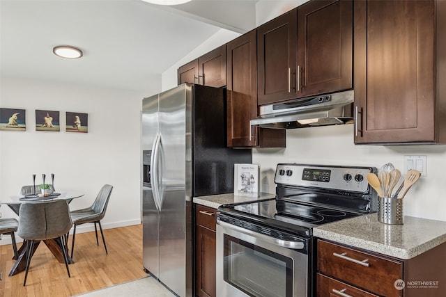 kitchen featuring stainless steel appliances, light stone countertops, dark brown cabinets, and light hardwood / wood-style flooring